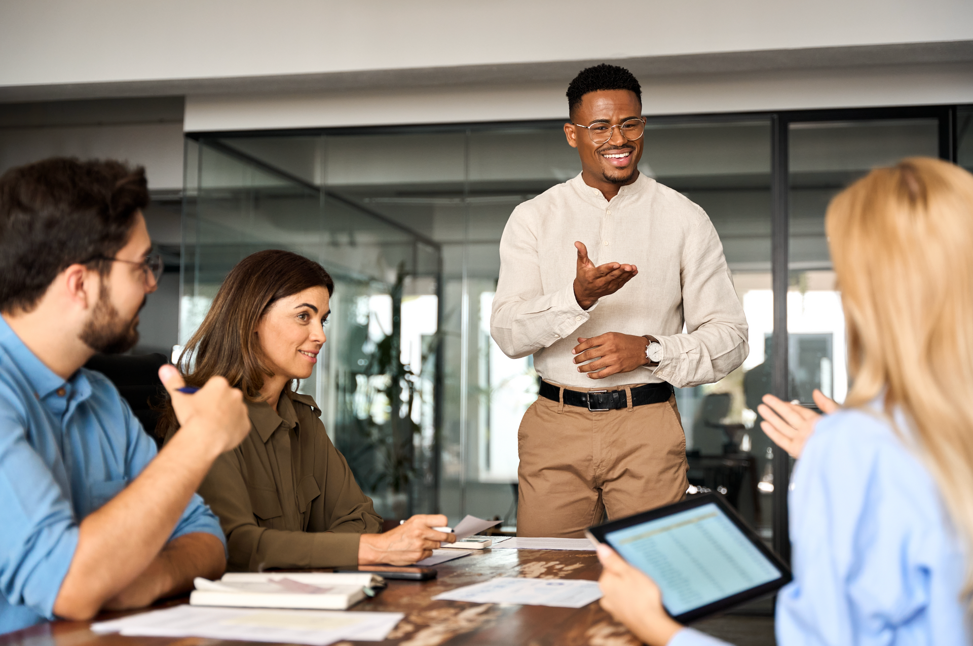 A group of people are sitting around a table having a meeting.