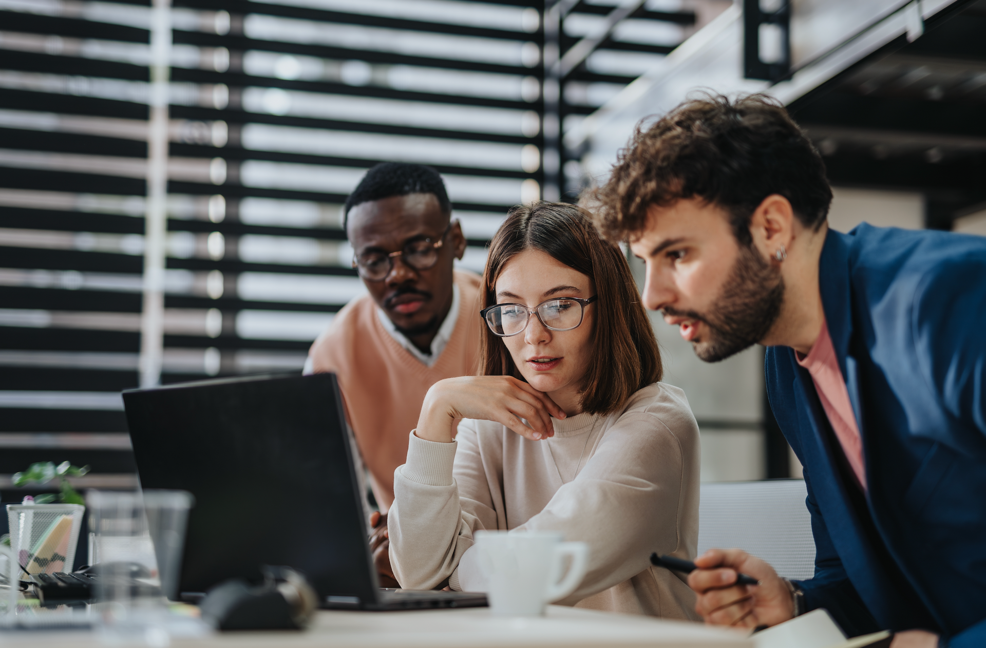 A group of people are looking at a laptop computer.