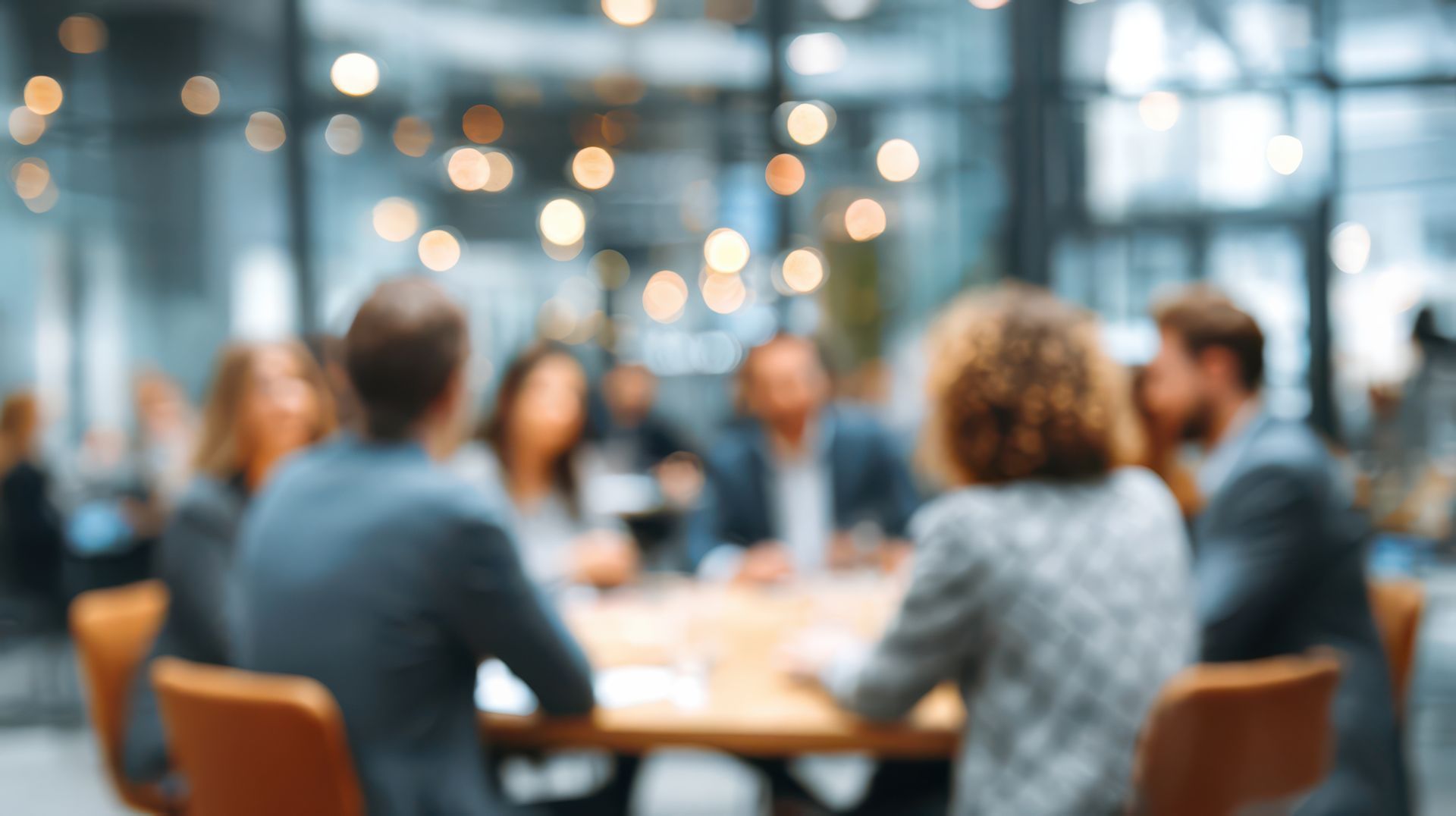 Three coworkers in a meeting, discussing over documents at a conference table