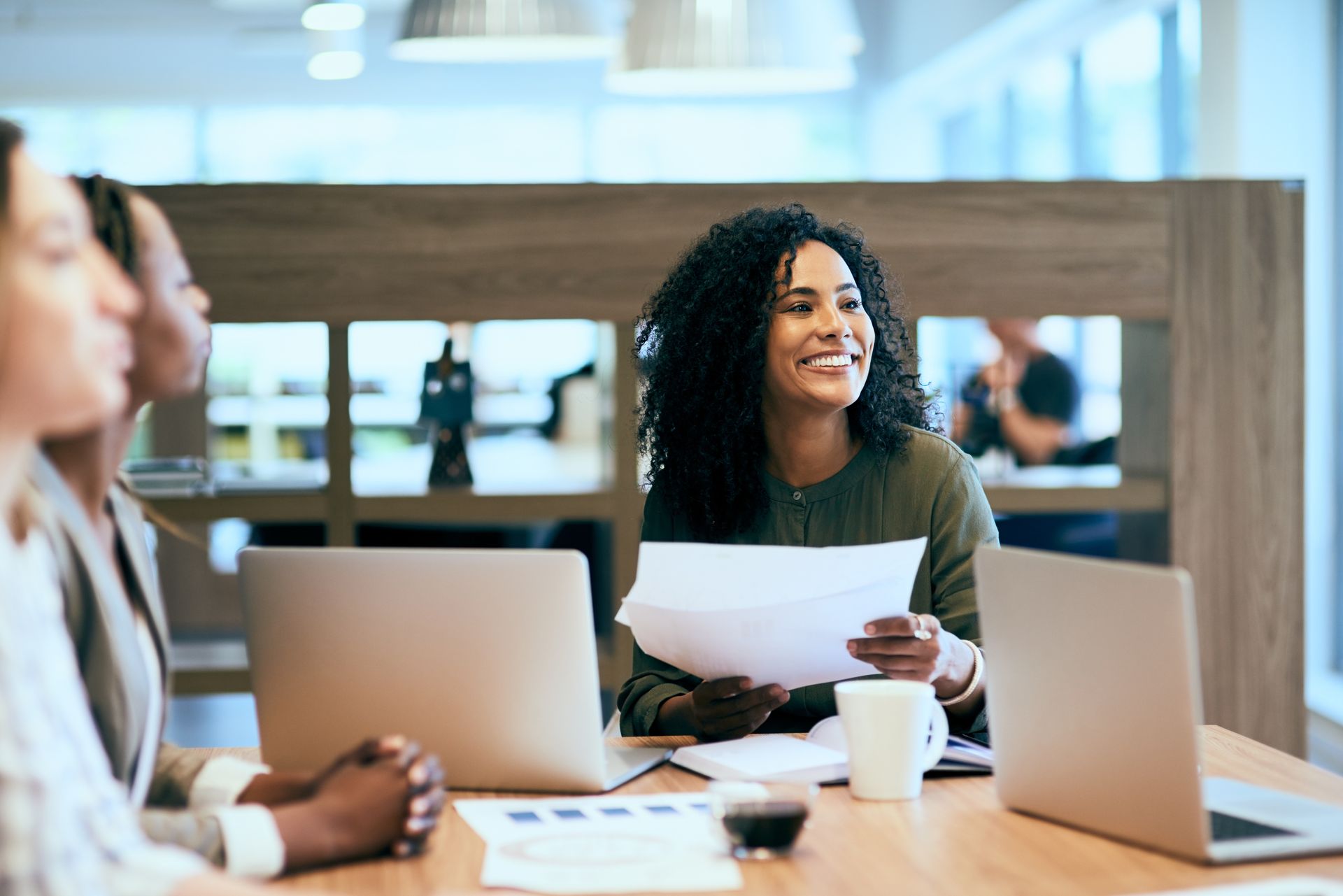 Business meeting with four people discussing documents in a bright office