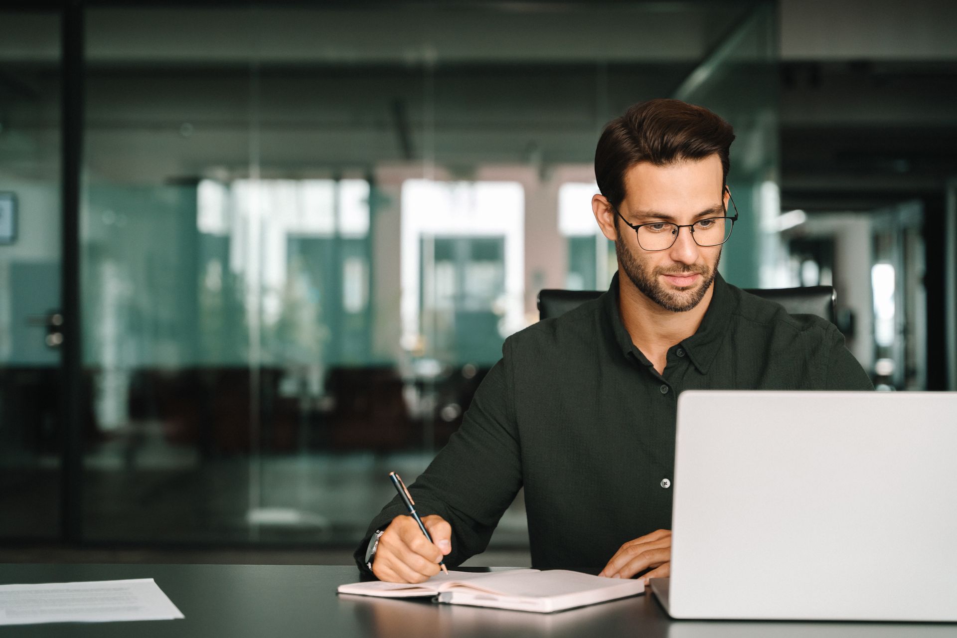 Two coworkers reviewing a document in a bright office near a computer monitor