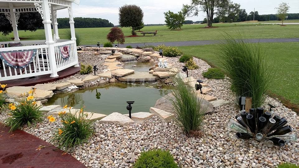 Backyard pond with a tiered flagstone waterfall and river rock border
