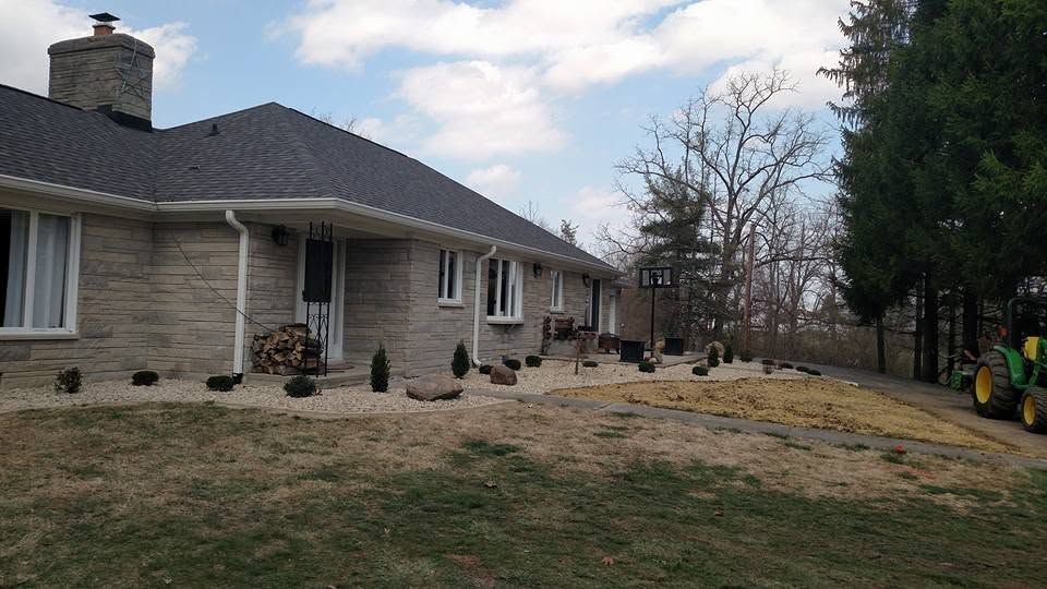 Finished front yard landscape beds at a one-story stone home.