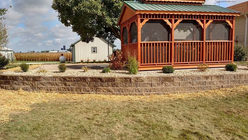 Wooden gazebo with green roof in a professionally landscaped backyard