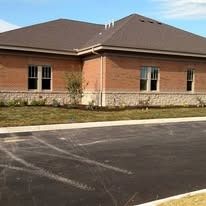 Brick commercial building with clean foundation landscaping and an asphalt parking lot