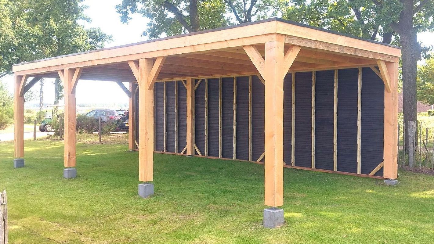 Een houten constructie staat midden in een weelderig groen veld.