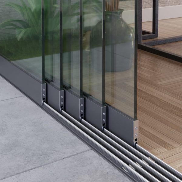 Detailopname van een meerdelig schuifdeursysteem van glas, gemonteerd op een donkere metalen rail, dat de binnen- en buitenruimte scheidt.