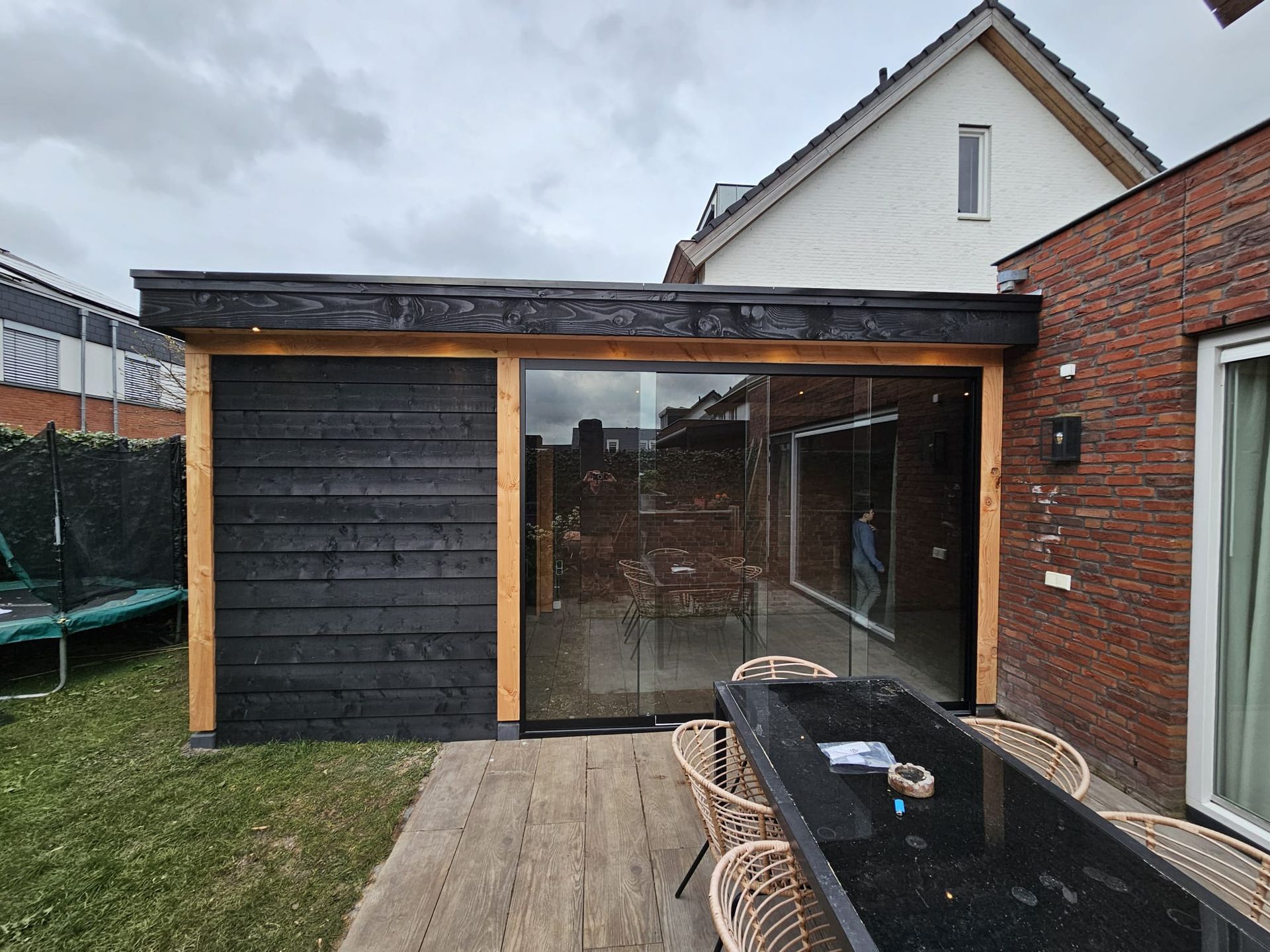 Een terras met een tafel en stoelen voor een huis.