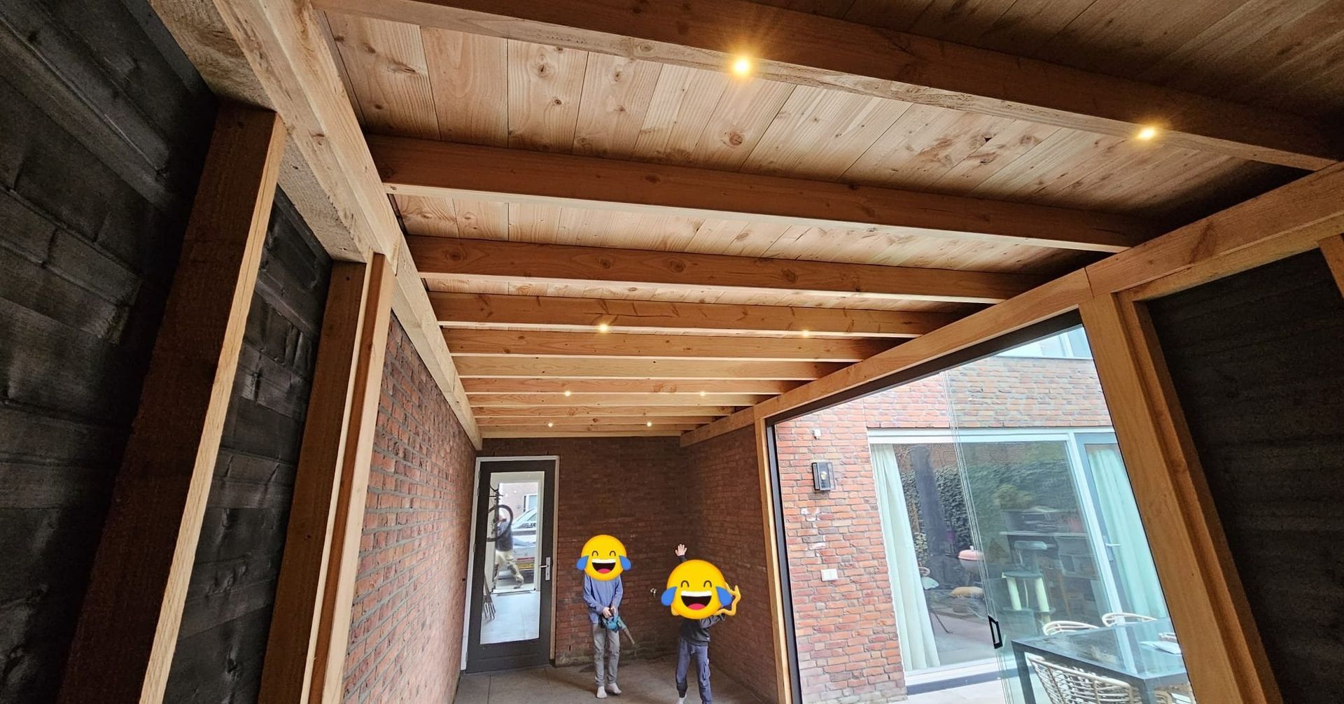 Een paar mensen staan ​​in een gang onder een houten plafond.