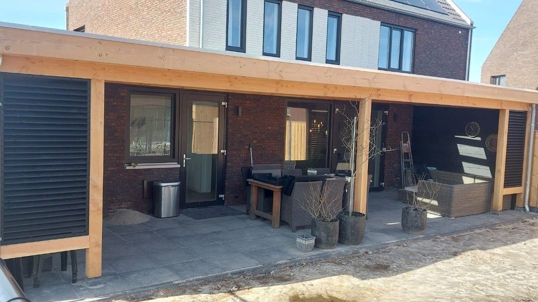 Een huis met een houten overdekt terras ervoor.
