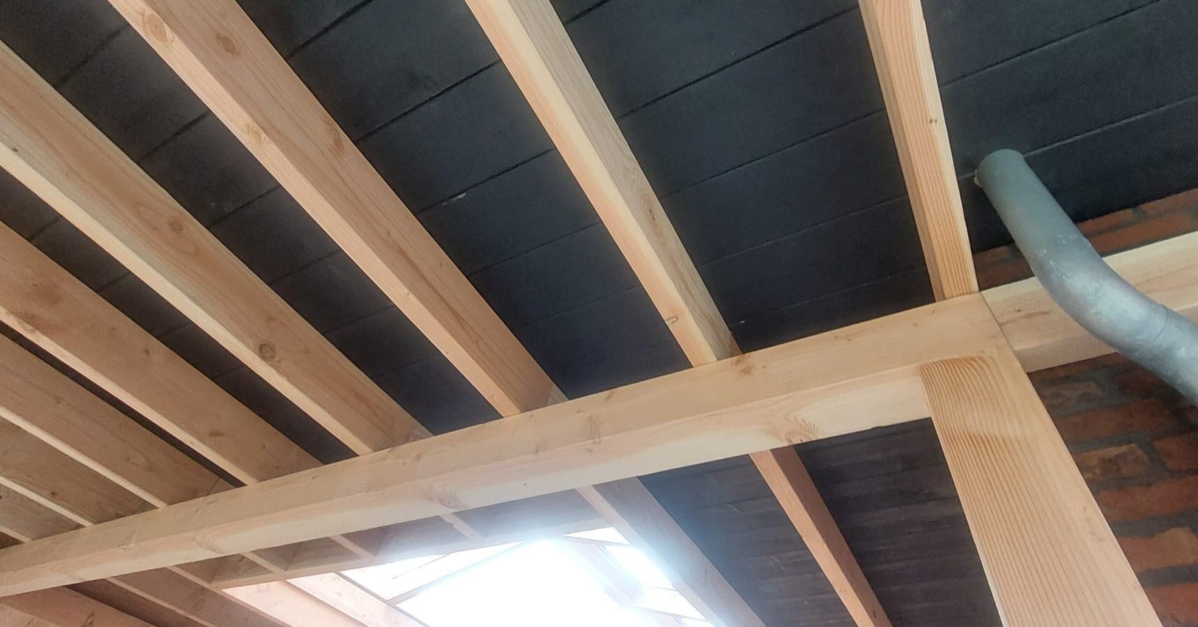 Het plafond van een gebouw wordt gebouwd met houten balken.