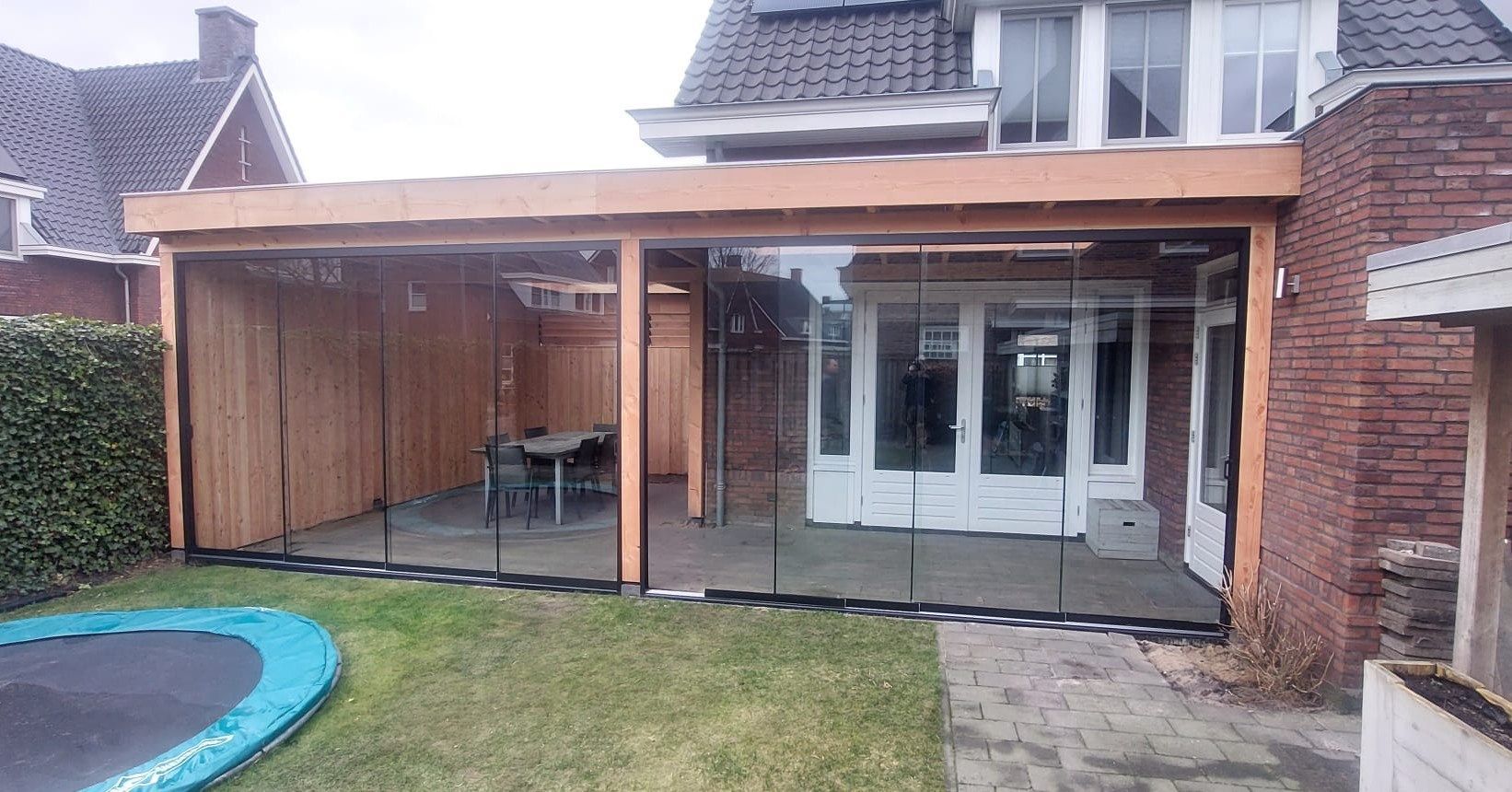 Er staat een trampoline in de achtertuin van een huis.