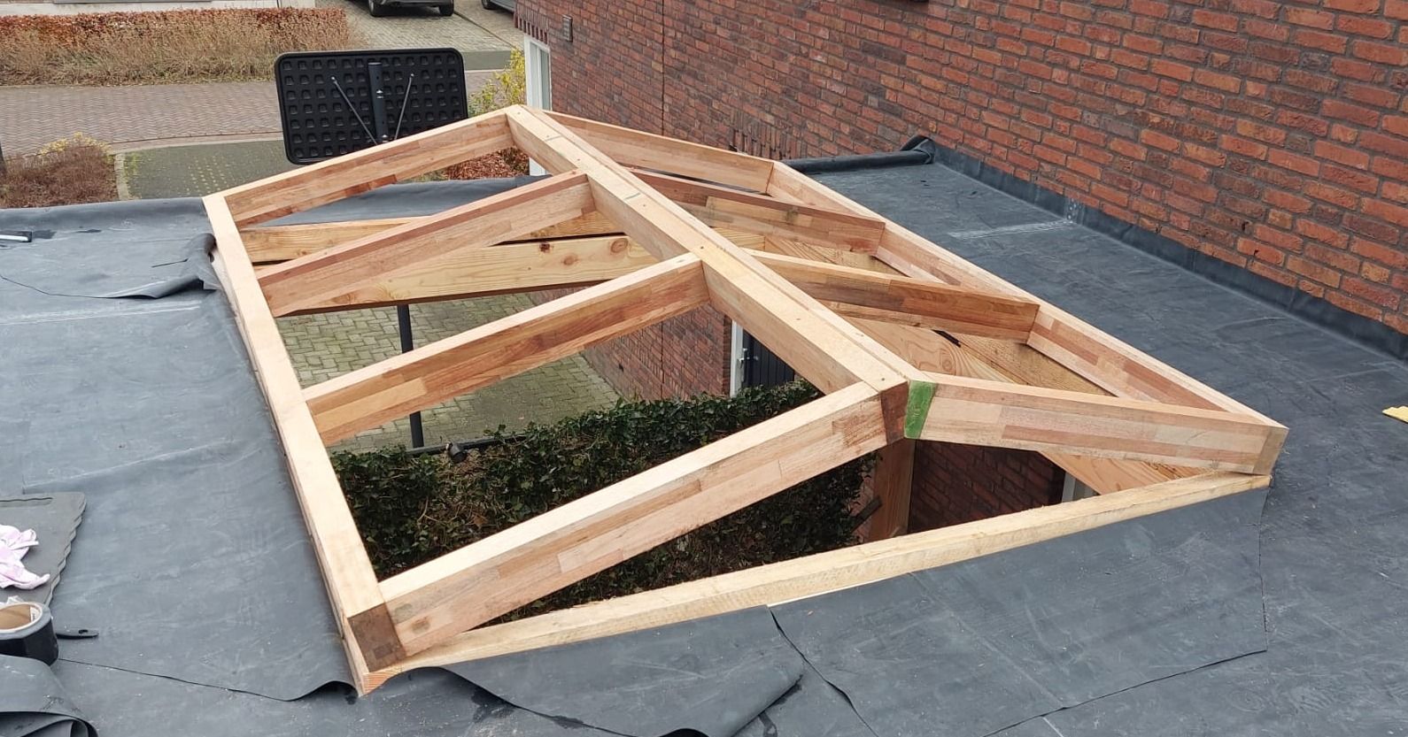 Er wordt een houten constructie op een dak gebouwd.