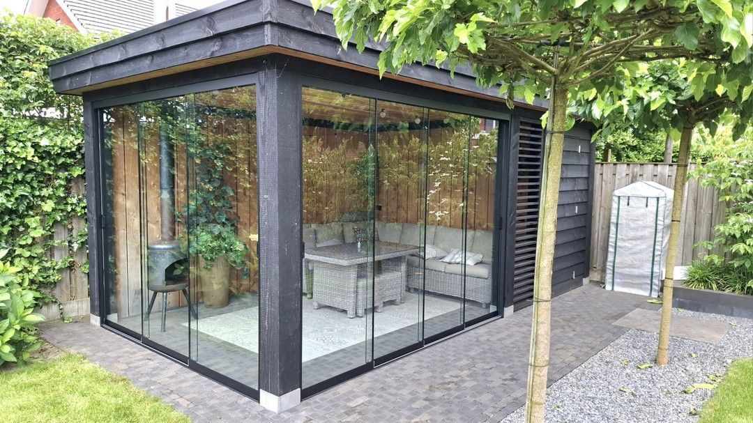 Er is een prieel met glazen schuifdeuren in de achtertuin.