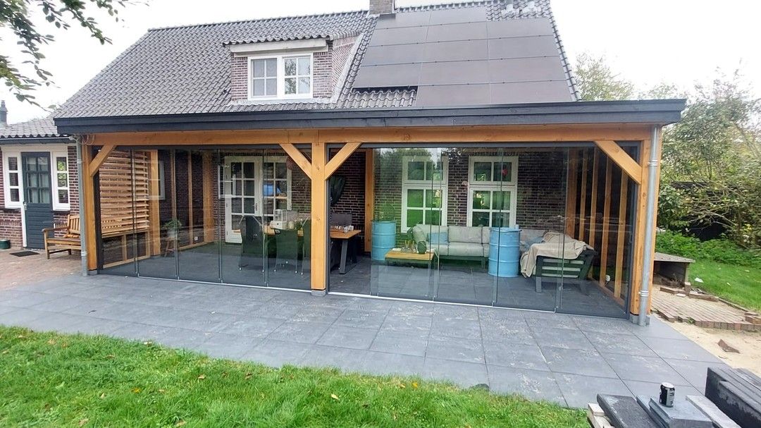 Een huis met een groot overdekt terras ervoor.