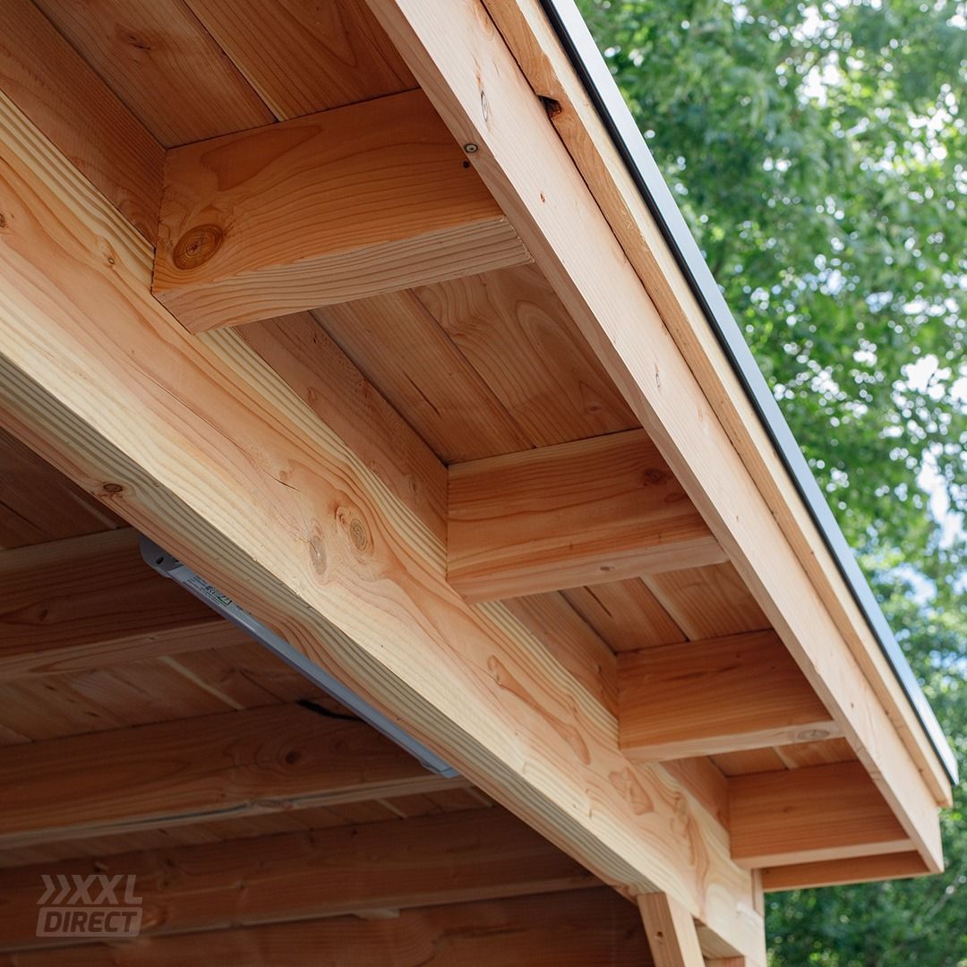 Een close-up van de onderkant van een houten dakoverhang, met balken, spanten en cederhouten planken met natuurlijke nerf.