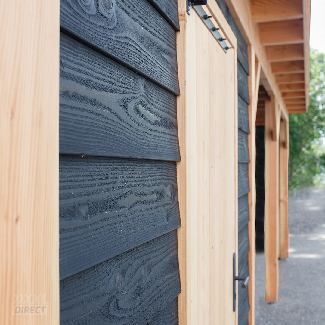 Een constructie met zwart, antracietkleurig houten gevelbekleding, gecontrasteerd door licht houten sierlijsten en steunpalen.