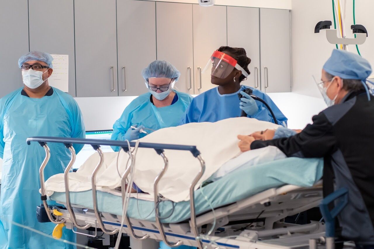 four medical professionals wearing sterile surgical gowns