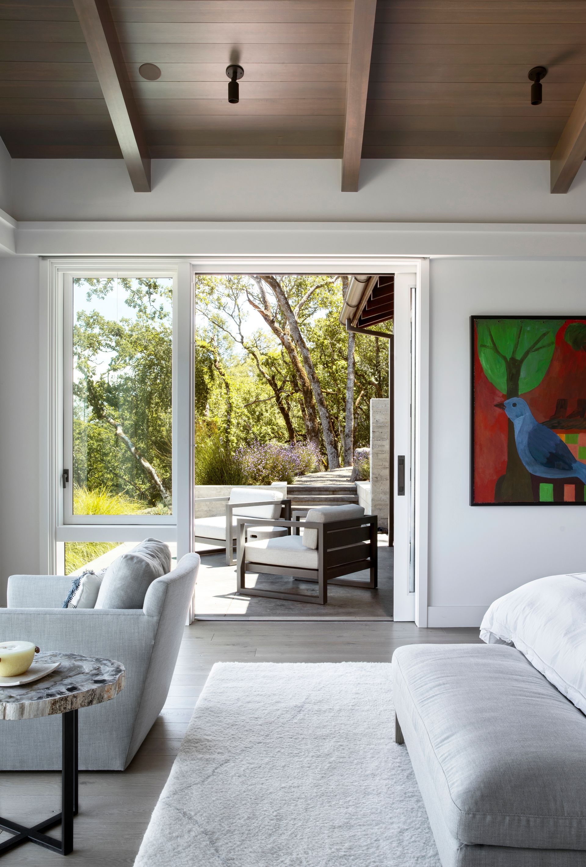 Bedroom interior with open sliding door to outdoor seating area built by Nunley Custom Homes in Greenville, SC.
