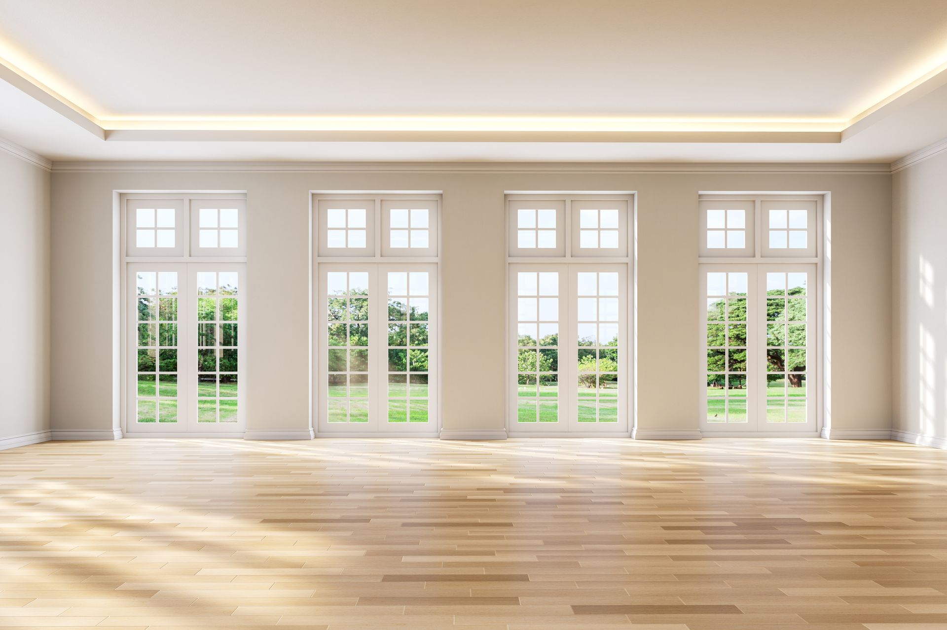 Empty living room with large windows, hardwood flooring, and neutral painted walls.