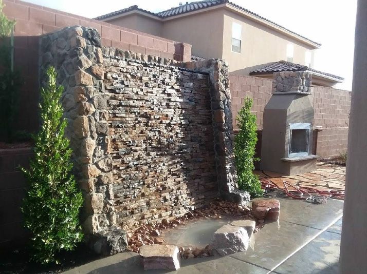 A stone wall with a fireplace in the background