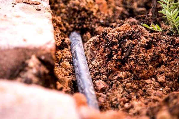 A close up of a pipe in the ground.
