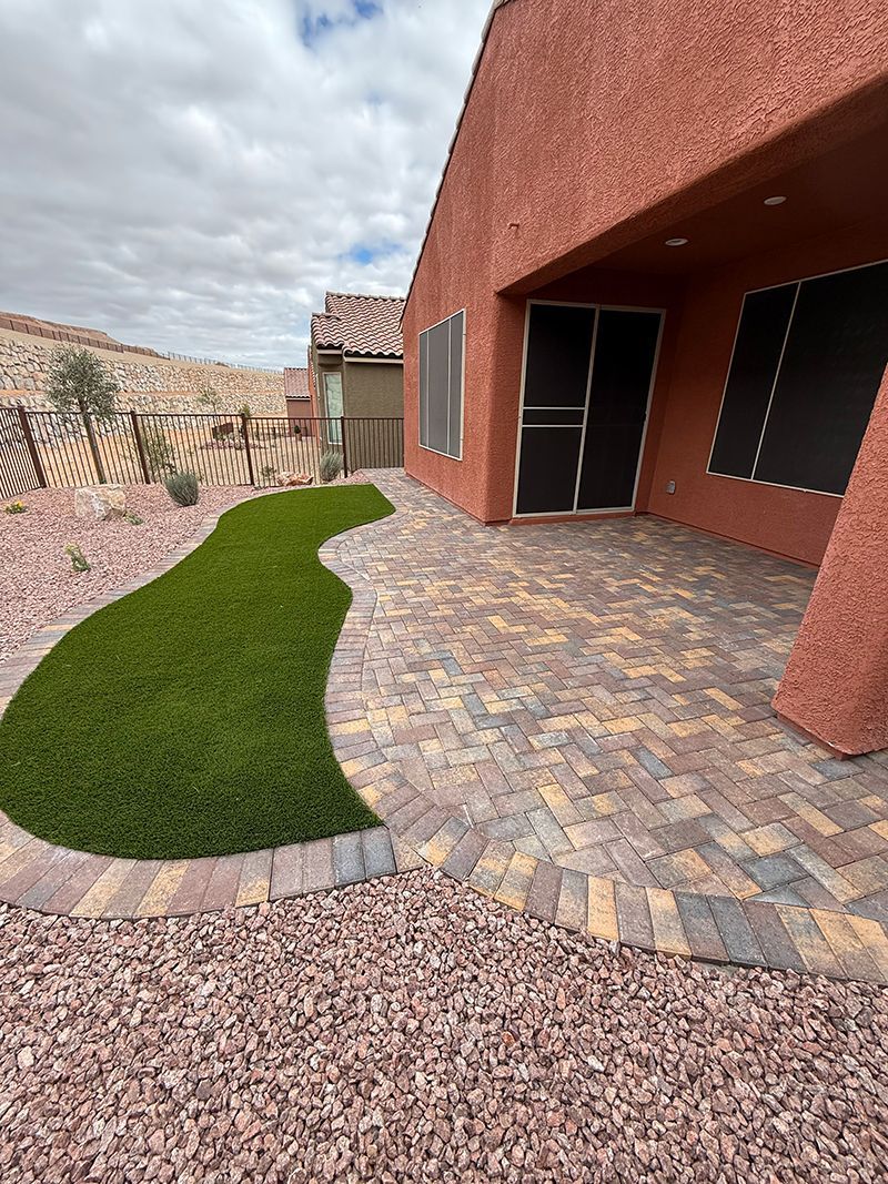 A house with a patio and a lawn in front of it.