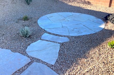 A circular walkway made of rocks and concrete is surrounded by gravel.