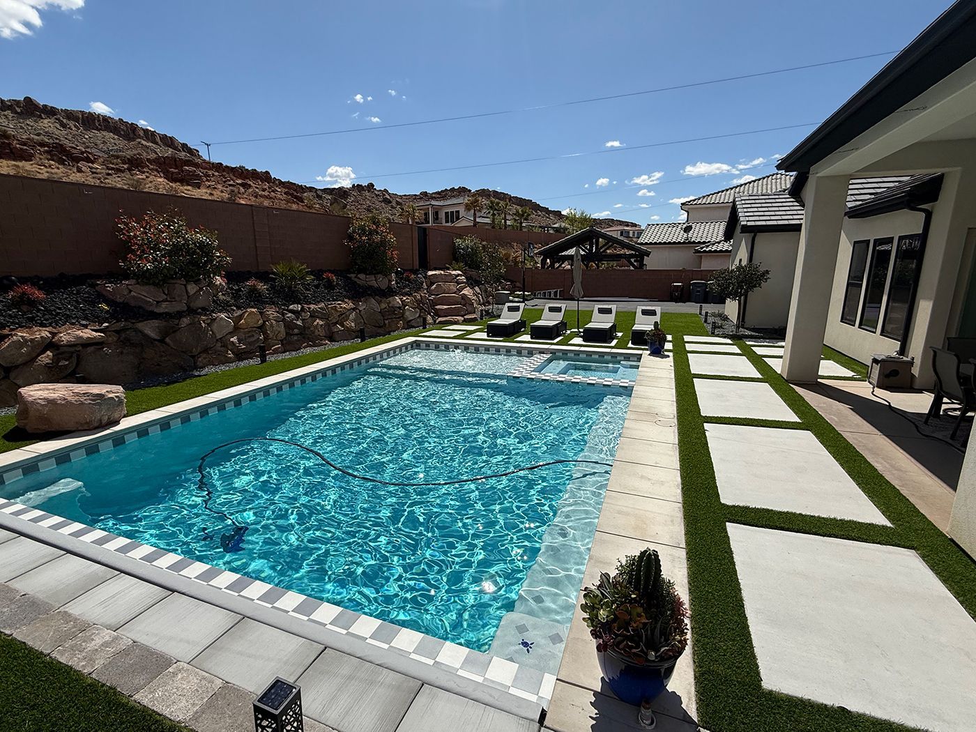 There is a large swimming pool in the backyard of a house.