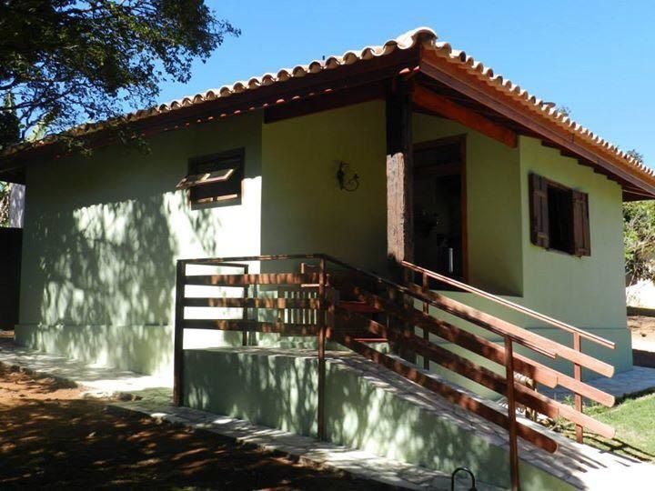 Estufa com grades de madeira e telhado de telha marrom.