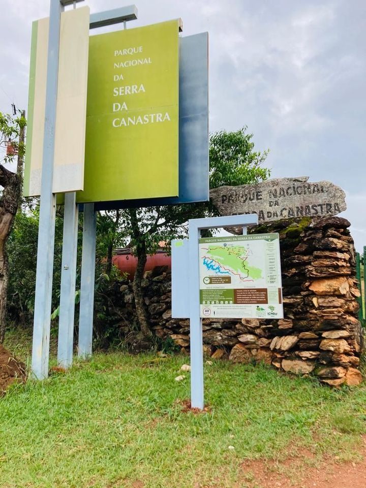 Sign for Parque Nacional da Serra da Canastra, with map and information board, near a stone wall.