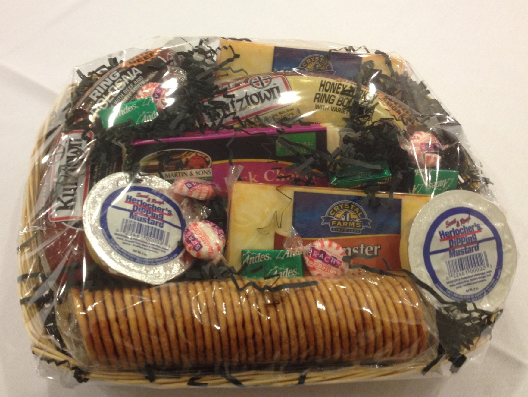 A wicker basket filled with crackers cheese and candy