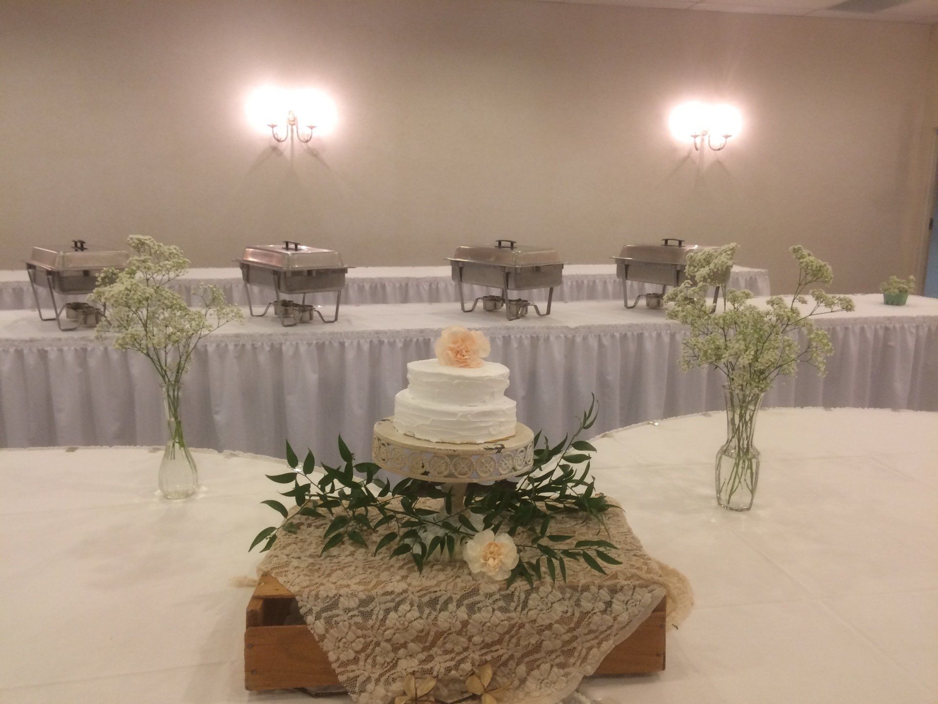 A wedding cake is sitting on top of a wooden box on a table.