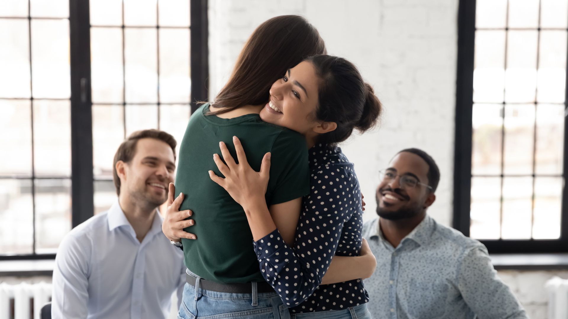 A Group of People Are Hugging Each Other in a Room