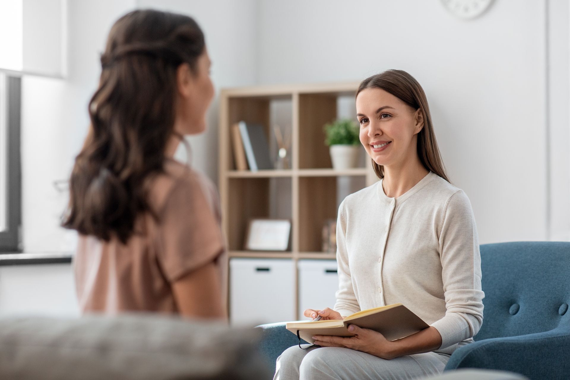 A Woman is Sitting in a Chair Talking to a Young Girl