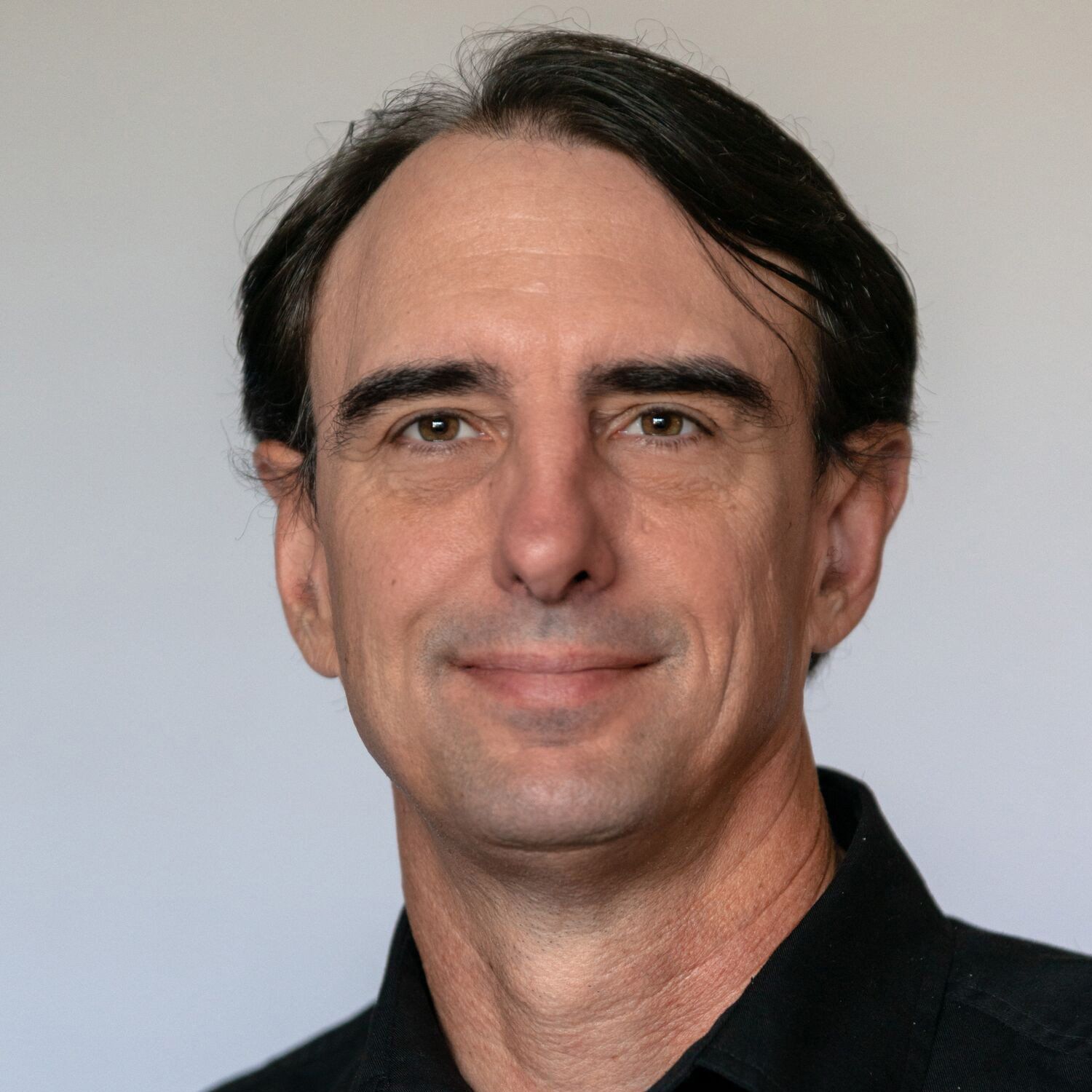 a man wearing a black shirt is smiling for the camera