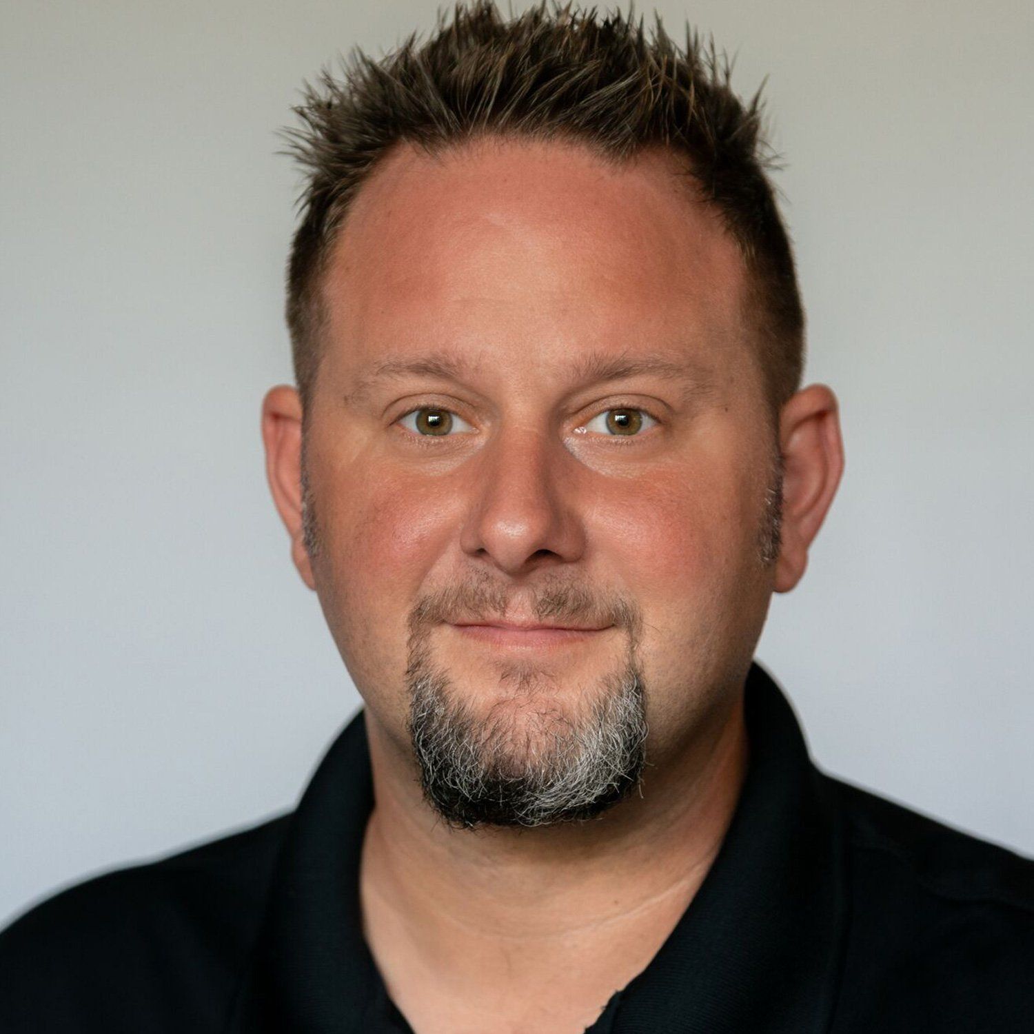 a man with a beard is wearing a black shirt