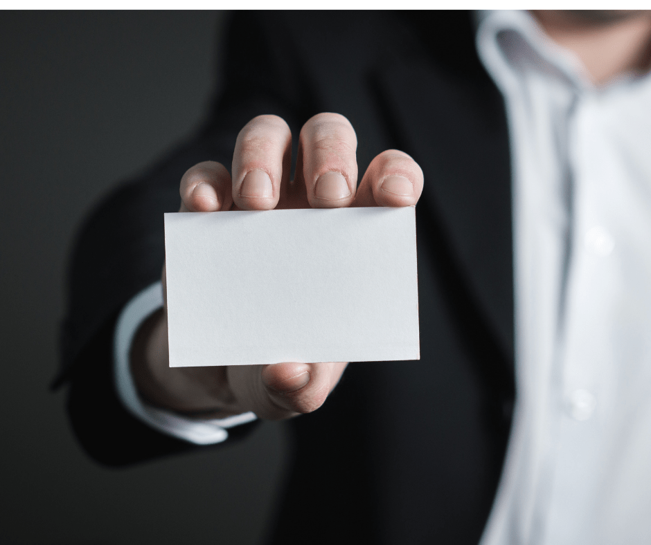 Man in suit holding a blank business card forward. Man in suit holding a blank business card forward.