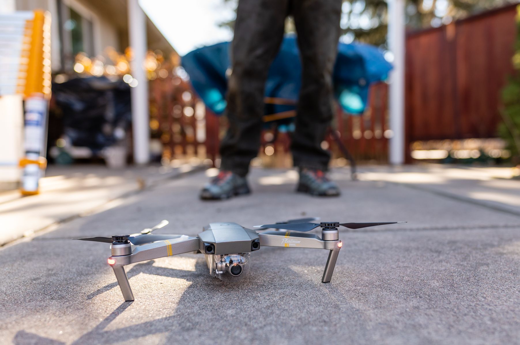 Small drone on a street, with a person standing blurred in the background.