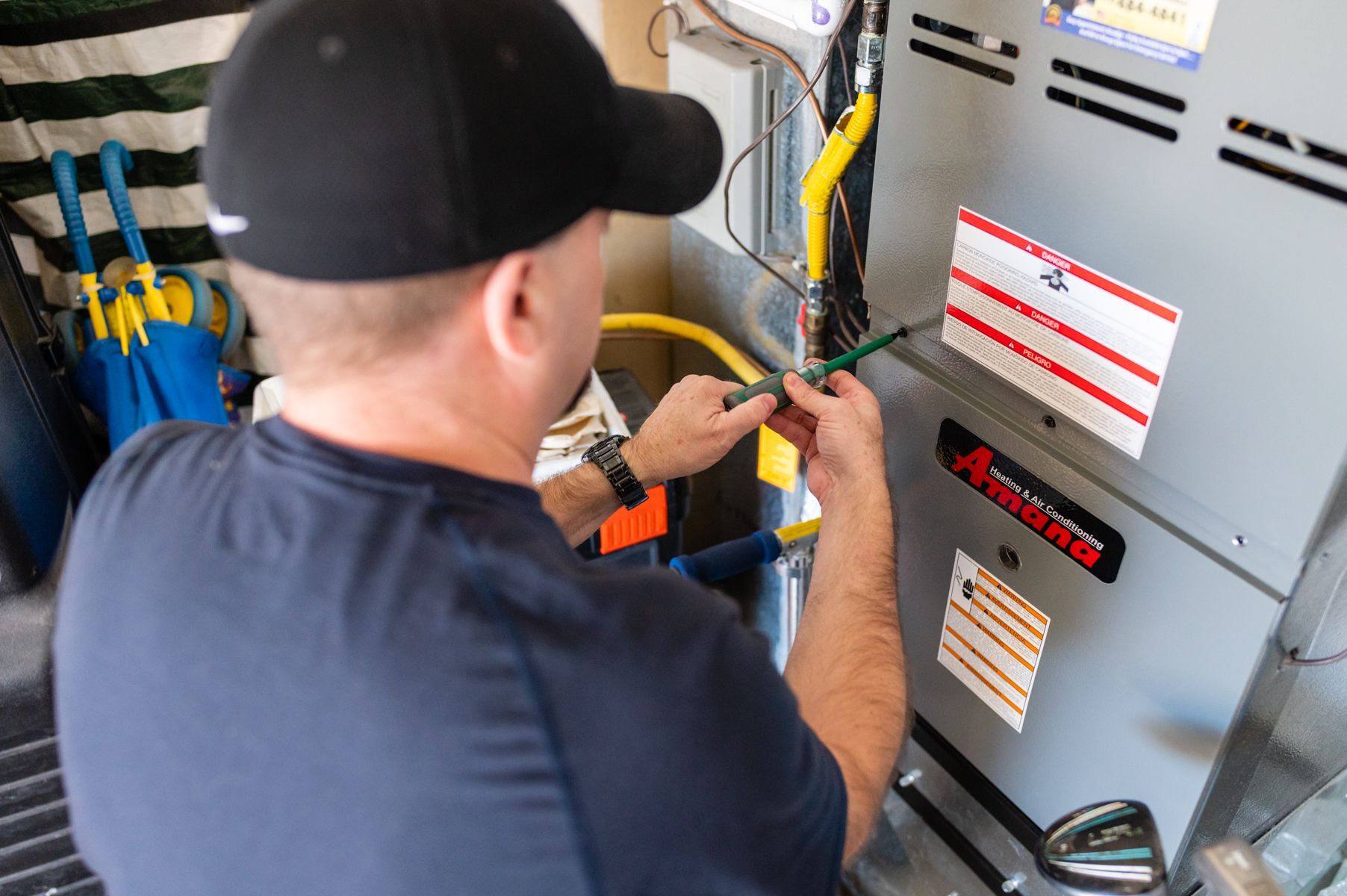 Technician wiring an electrical panel with tools in a utility room