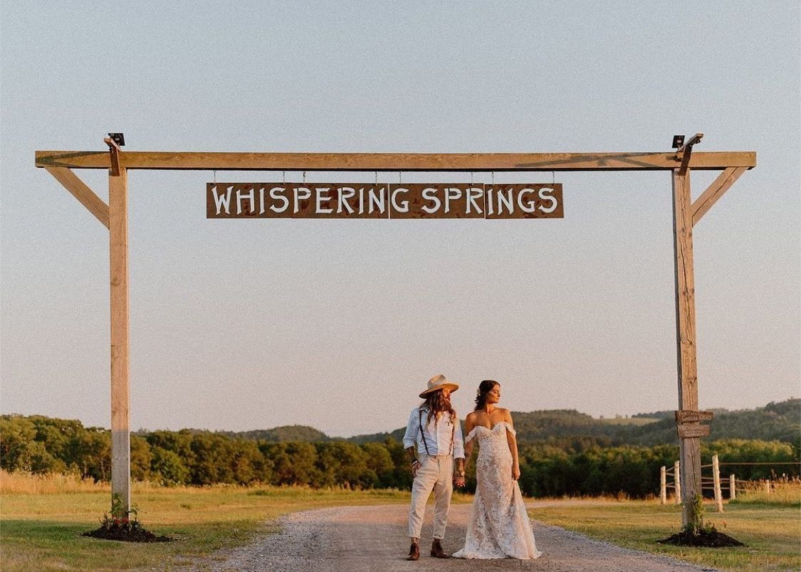 Wedding couple underneath the iconic Whispering Springs sign 