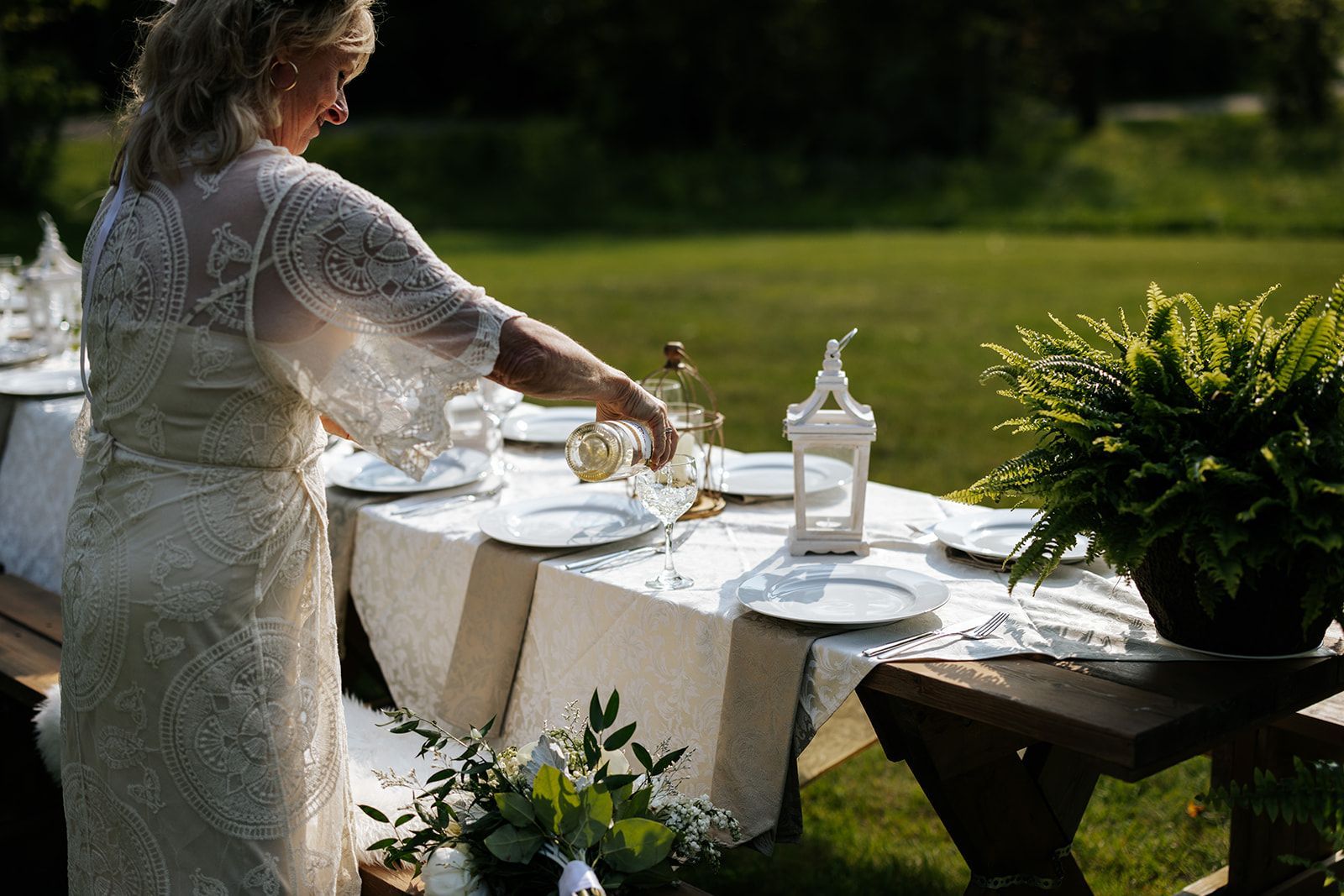 A bride pours a drink during the elopement celebration