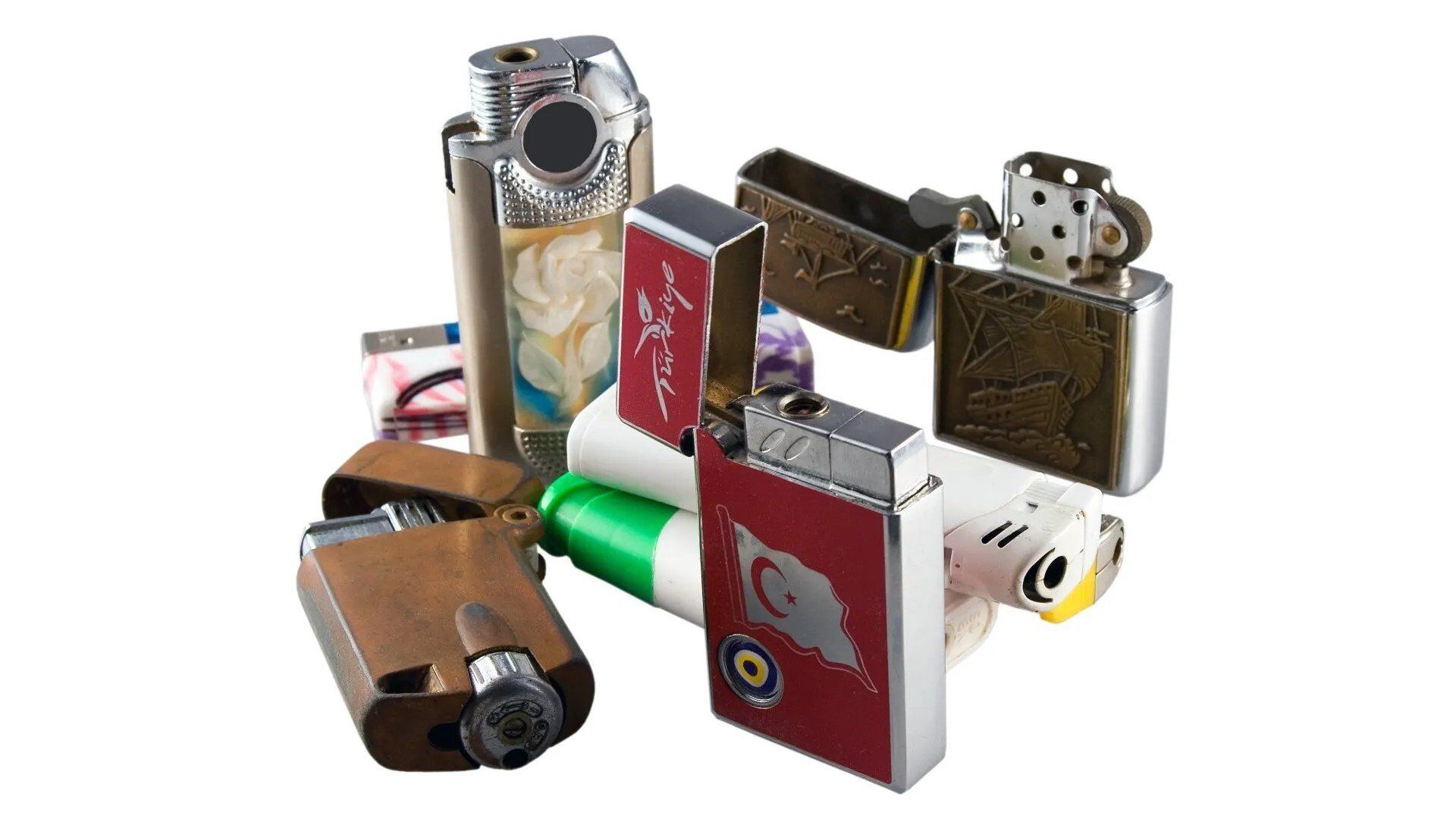 Flamable Materials — Lewisville, TX — AAA Recycling, Inc. Collection of various lighters; metallic, with different designs, and colors, on a white background.
