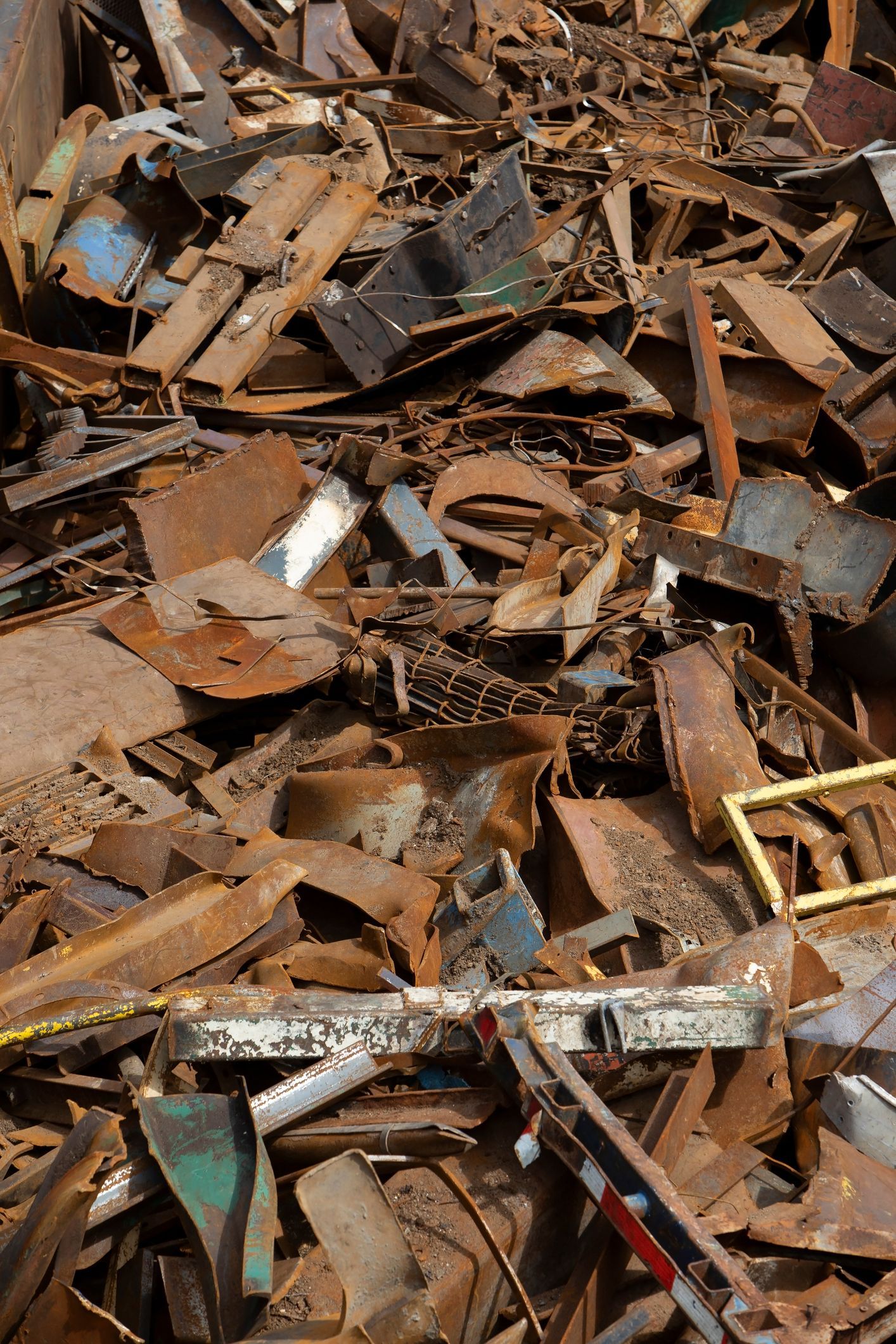 Pile of rusty, discarded metal scraps, likely at a recycling facility.