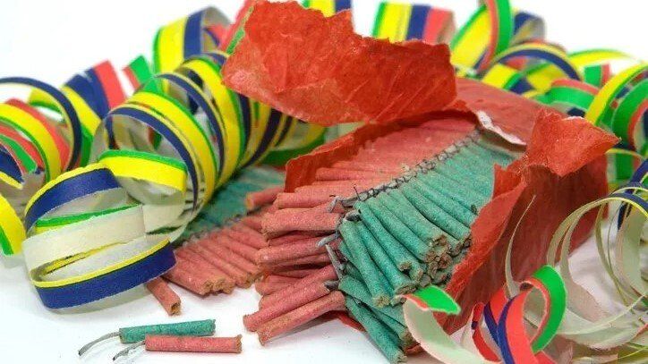 Fireworks — Lewisville, TX — AAA Recycling, Inc. Confetti and firecrackers on a white surface. Colorful curled paper and red-and-green firecracker casings.