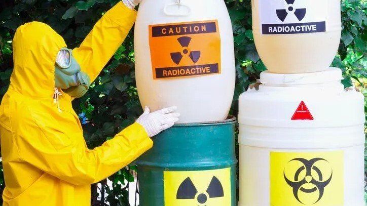 Radioactive Material — Lewisville, TX — AAA Recycling, Inc. Person in hazmat suit near barrels labeled