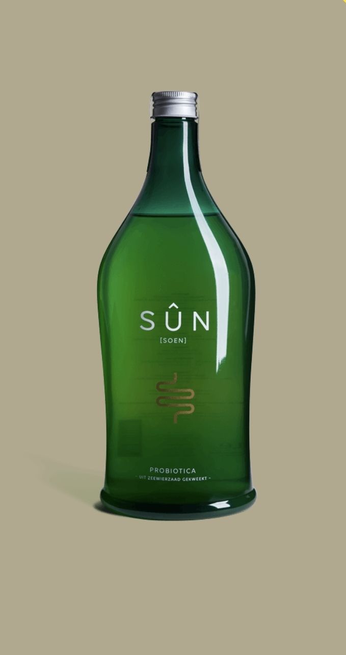 Groene glazen SUN-fles met zilveren dop op een effen beige achtergrond.
