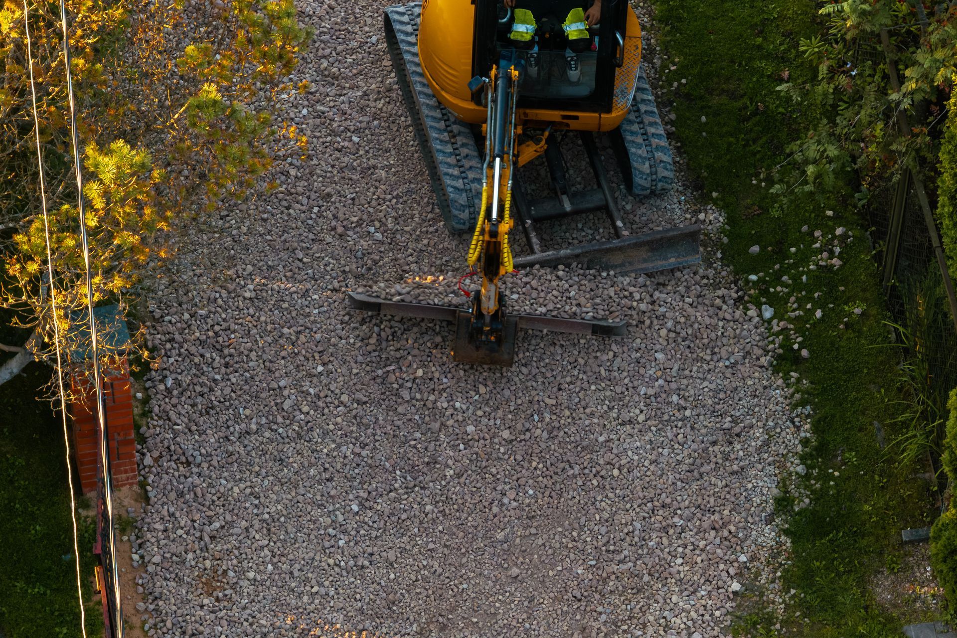 Gravel pathway under construction with excavator in the distance and dirt edges on both sides