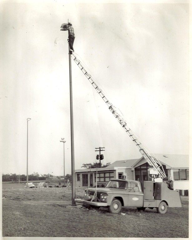 A black and white photo of a truck with a ladder attached to it