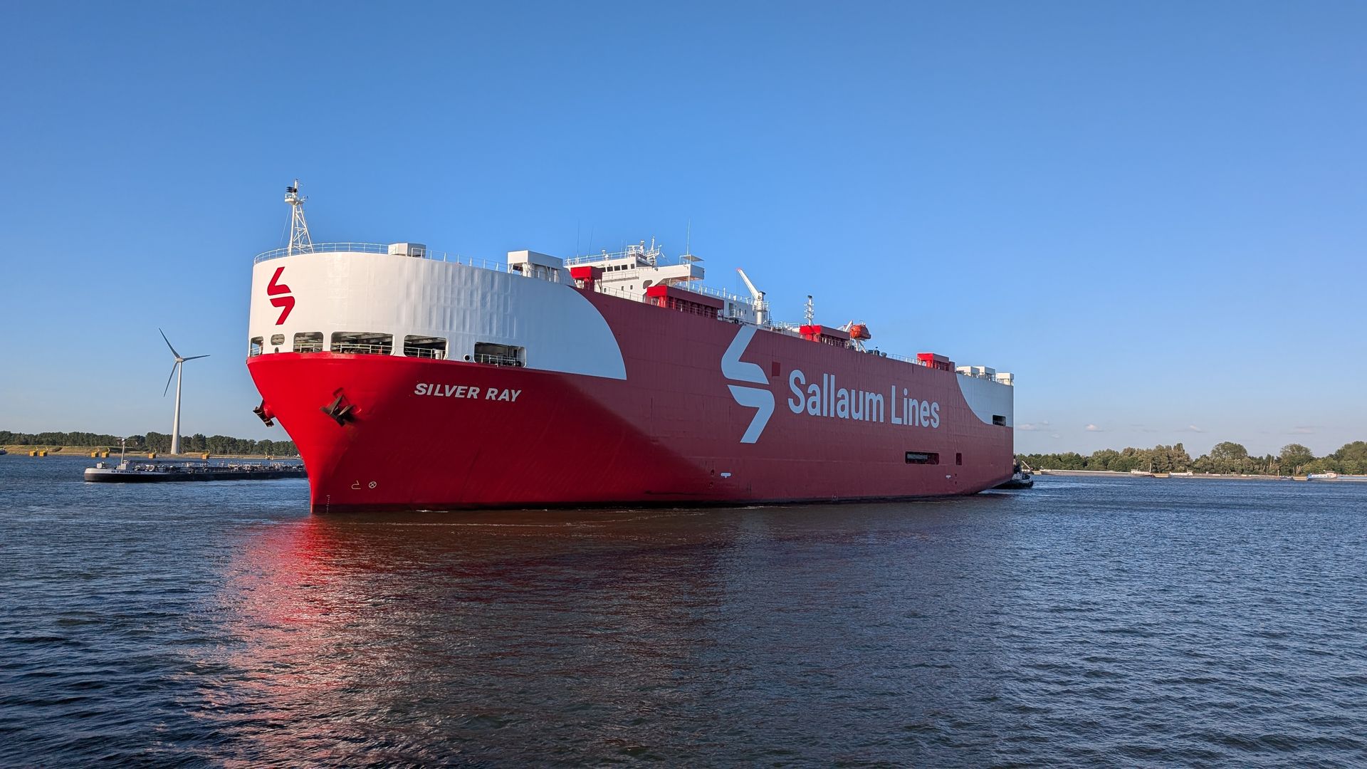 Rotes Autotransportschiff „Buffalo Bay“, das unter blauem Himmel auf dem Wasser segelt.